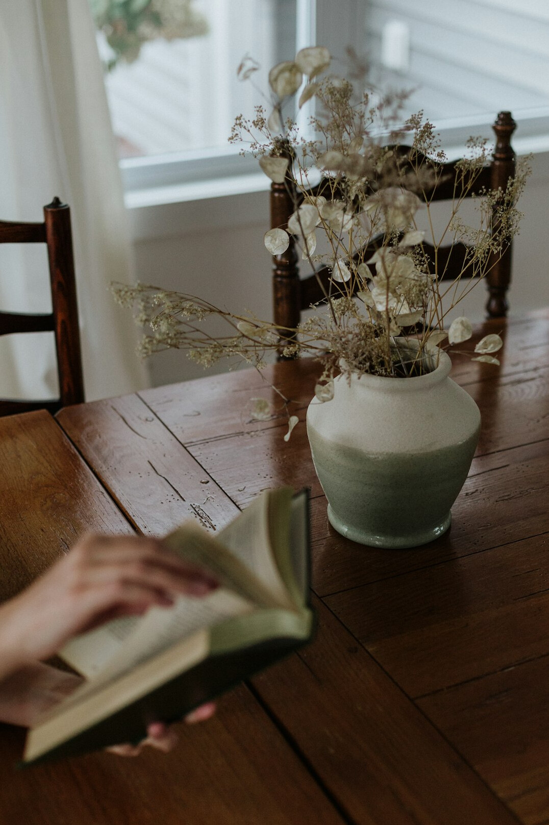 Woman in her fifties writing in a notebook on a living room sofa