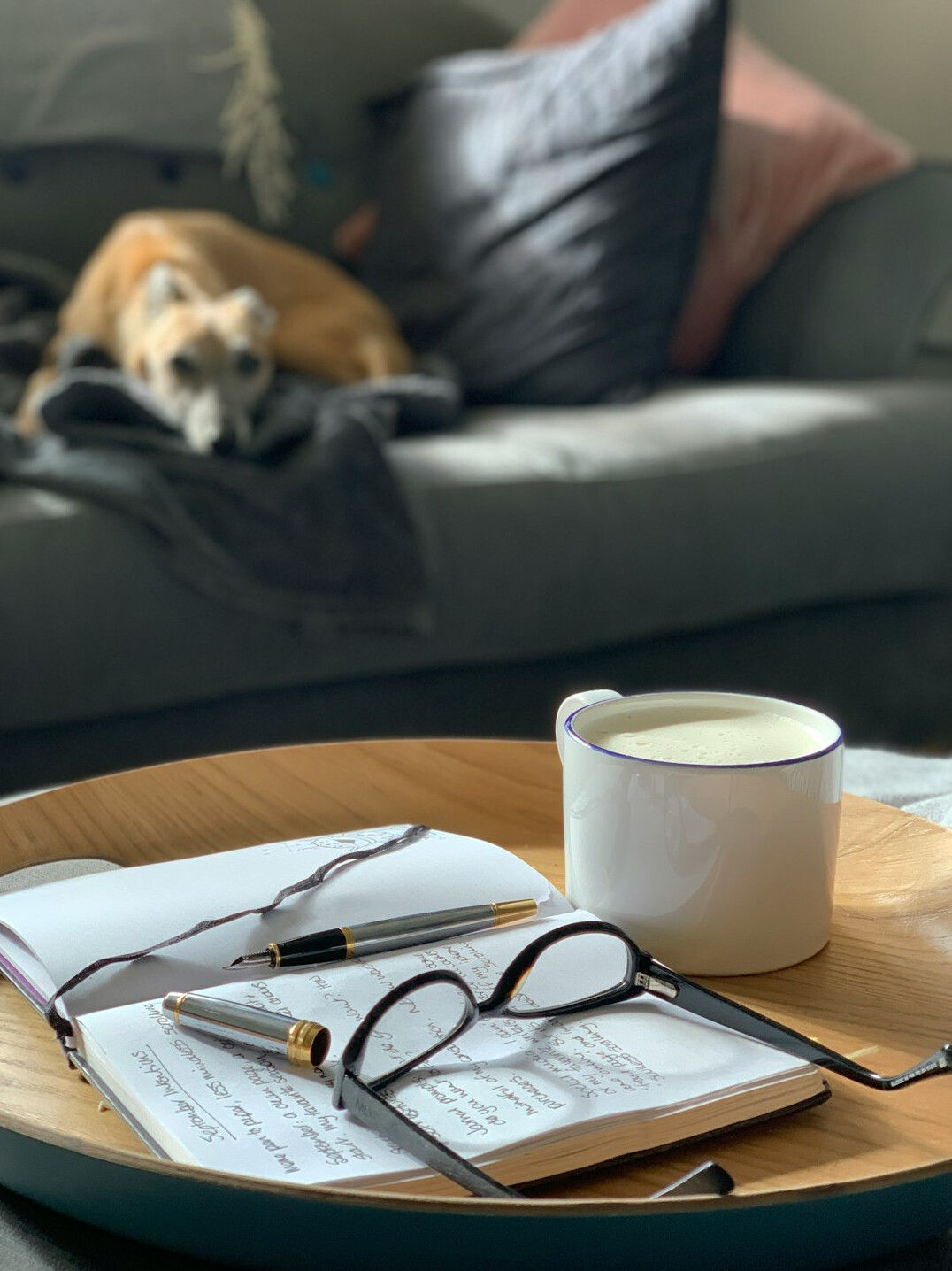 Wooden table with notebook, calculator, reading glasses and coffee for household budgeting